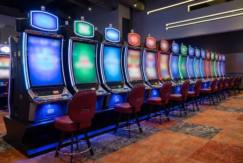 Slot machine rows with red stools on the casino floor